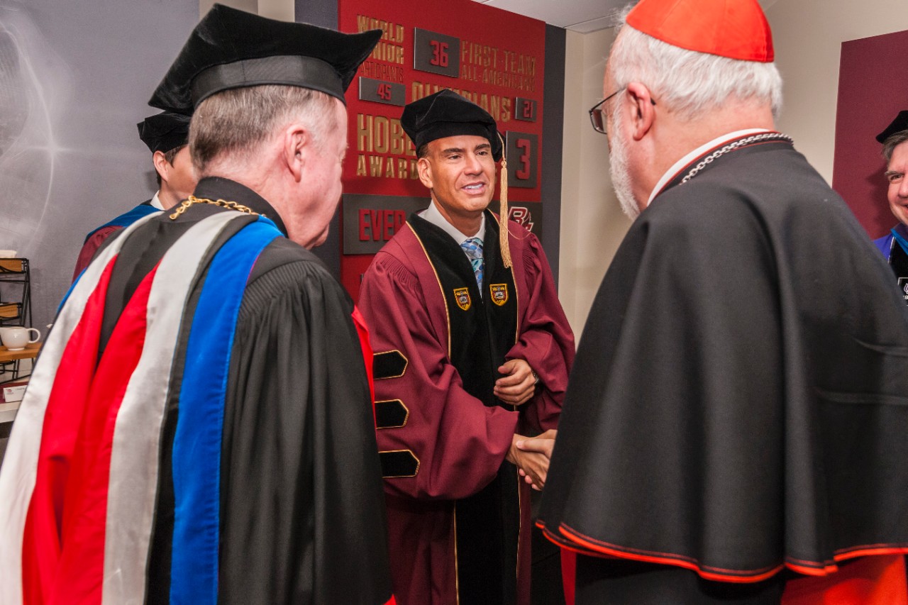 Honorary degree recipient Alberto Vasallo III 89, president and CEO of El Mundo Boston, greets Cardinal Seán O'Malley, OFM., Cap., Archbishop of Boston, in the robing room, as BC administrators look on. Honorary degree recipient Alberto Vasallo III 89, president and CEO of El Mundo Boston, greets Cardinal Seán O'Malley, OFM., Cap., Archbishop of Boston, in the robing room, as BC administrators look on.