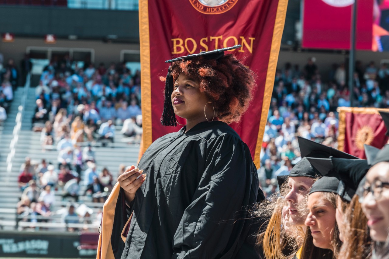 Student standing by school banner Student standing by school banner