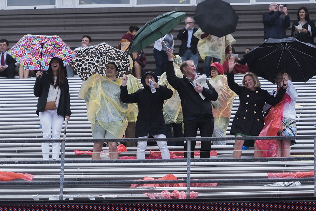 Family members dancing with umbrellas in the stands Family members dancing with umbrellas in the stands