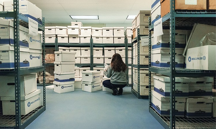 Student with artifacts in storage