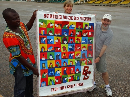 BC TechTrek Ghana leaders John Gallaugher and Elizabeth Bagnini with a welcome banner presented as a gift from bus driver Alex Asare, who has been with the program for three years. BC TechTrek Ghana leaders John Gallaugher and Elizabeth Bagnini with a welcome banner presented as a gift from bus driver Alex Asare, who has been with the program for three years.