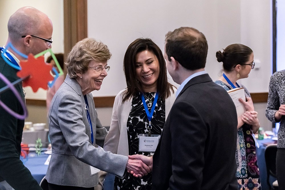 Mary Walsh and Deoksoon Kim greet fellow attendees.