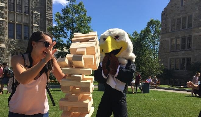 student playing jenga with Baldwin in the background