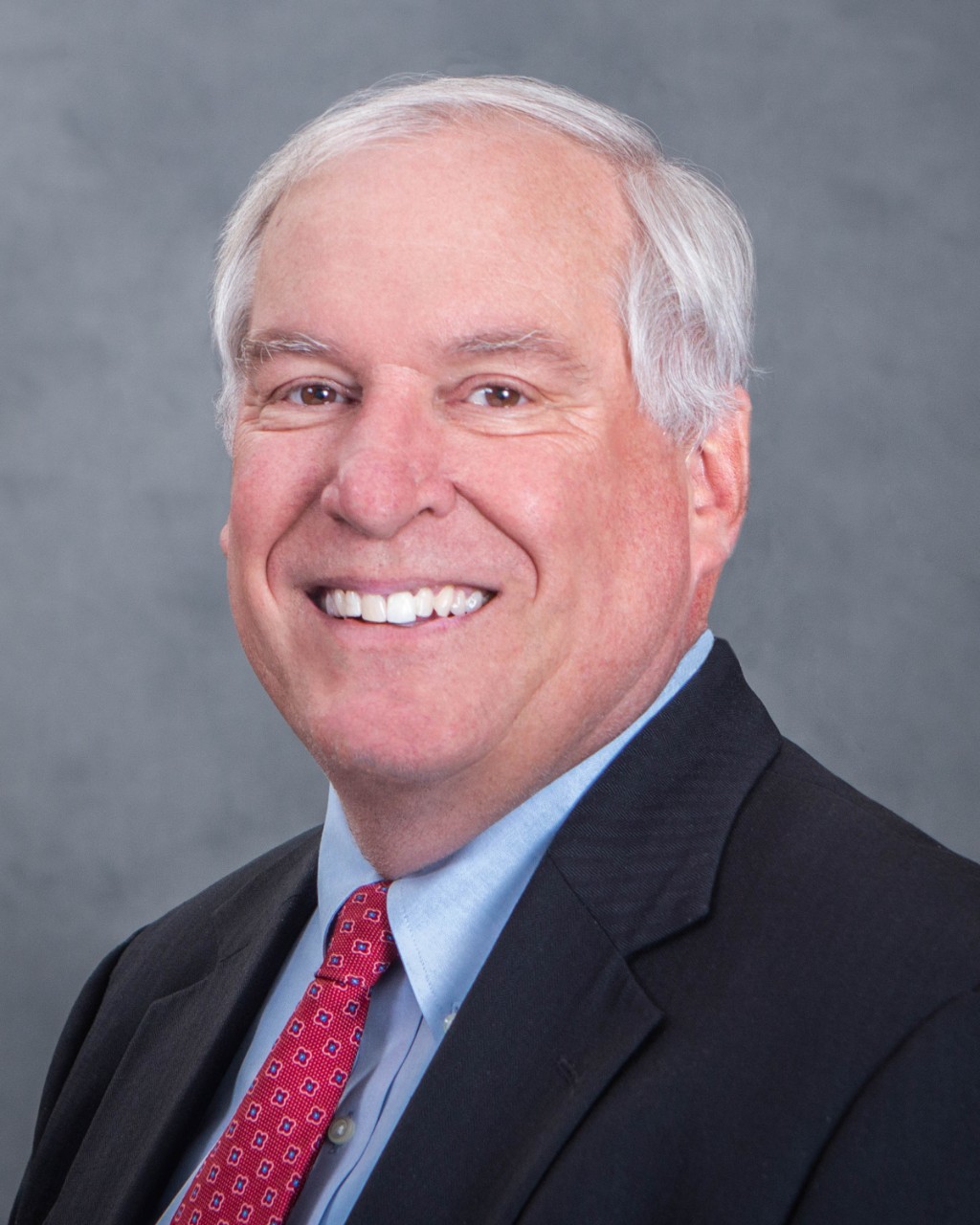 Headshot of Eric Rosengren, a smiling white man in a suit