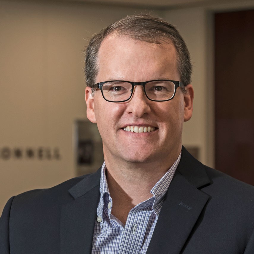 Andrew Dwyer in dark suit with checked shirt