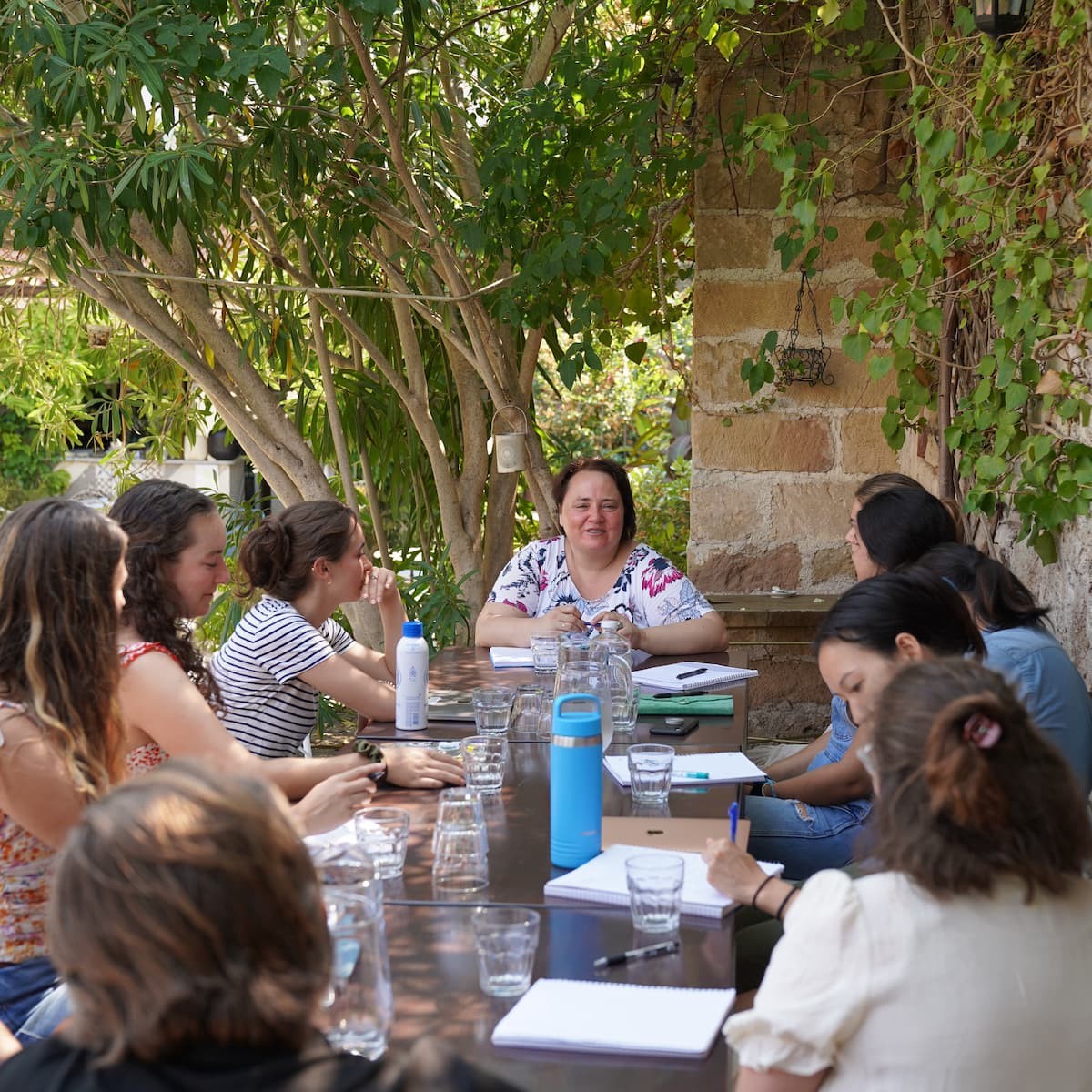 Students meet with Bosnian peacemaker Amra Pandzo in an outdoor classroom in Vis, Croatia