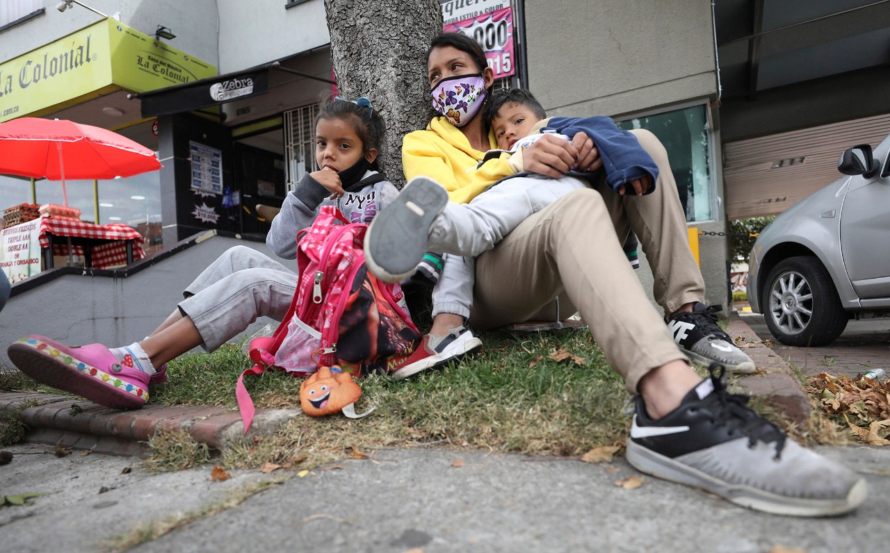 Venezuelan migrants reset outside a strip mall in Bogota, Colombia.