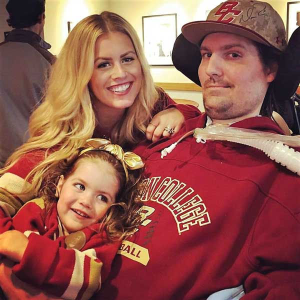 Frates seated with Julie at his shoulder and Lucy in his lap