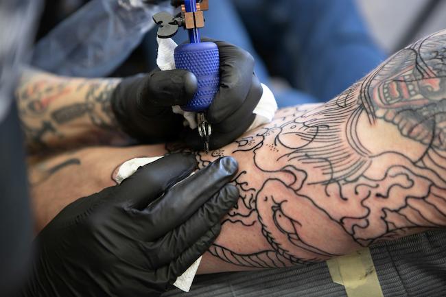 image of someone giving a tattoo