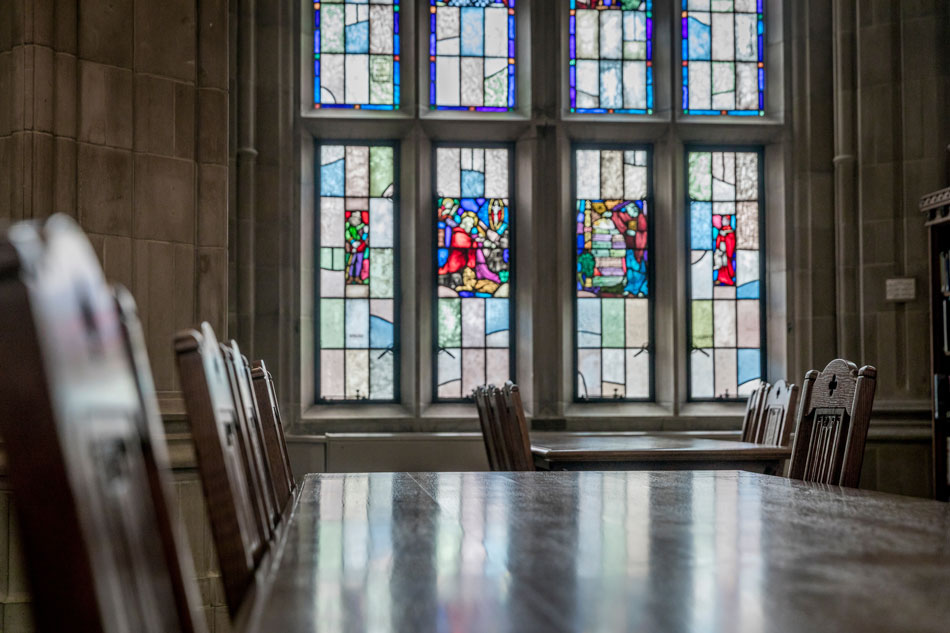 stained glass window in a conference room with a desk and chairs