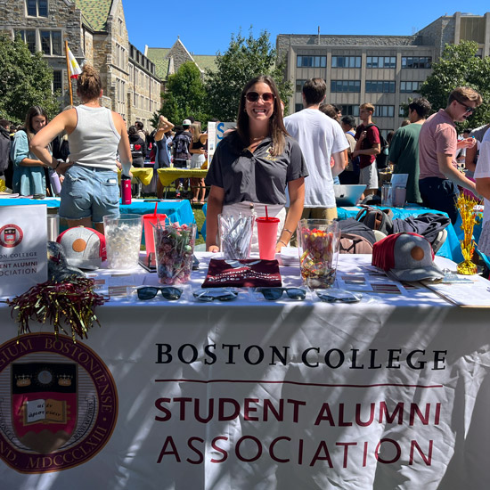 and student alumni association rep at a Student involvment fair table to promote the student alumni association