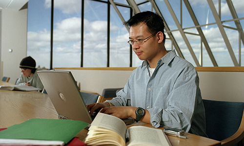 Student working on Laptop in O'Neill Library on Chestnut Hill Campus of Boston College