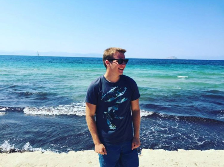A student standing on a beach