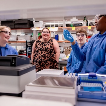 June 20, 2024 -- Emma Brace, Assistant Professor, Boston College Department of Engineering, with her students Avery Suza MCAS '26, Luke Baxter MCAS '27, and Melanie Cotta MCAS '26 in 245 Beacon. The team is conducting summer research completing xylitol assays, measuring how much xylitol the fermentations produced using a spectrophotometer. The assay causes a color change resulting in a gradient of samples/colors.