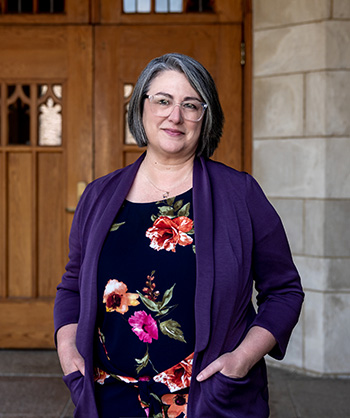 A portrait of Kathleen Flinton in a purple sweater and black dress