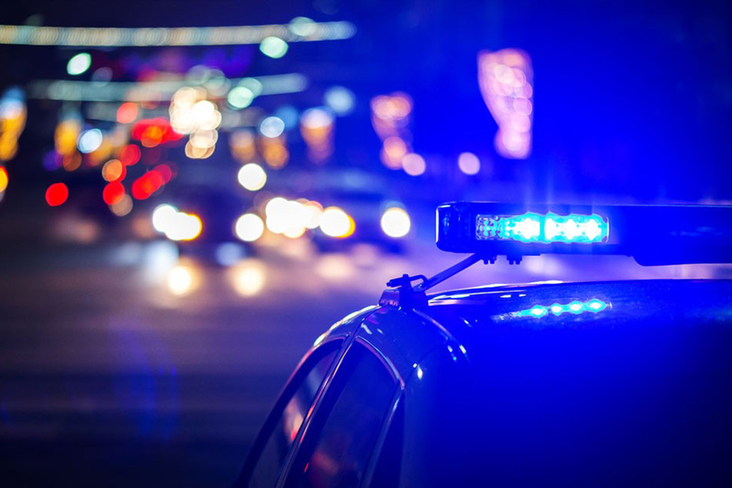 A phot of a police car with sirens on.