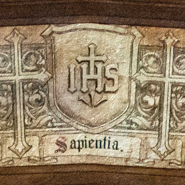 Detail of a shield bearing the IHS monogram of the Society of Jesus