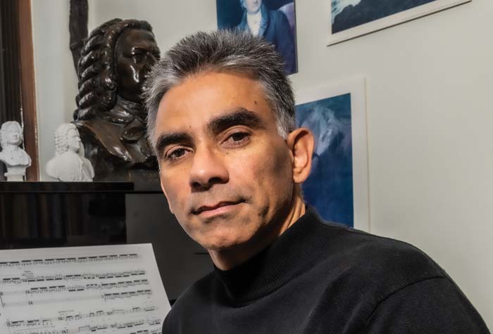 Ralf Gawlick seated at the piano in his office