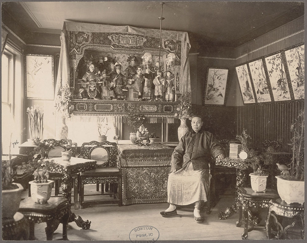 A historical photo of a man sitting in a Chinese restaurant