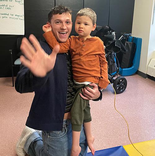 Tom Holland hugging a Campus School student