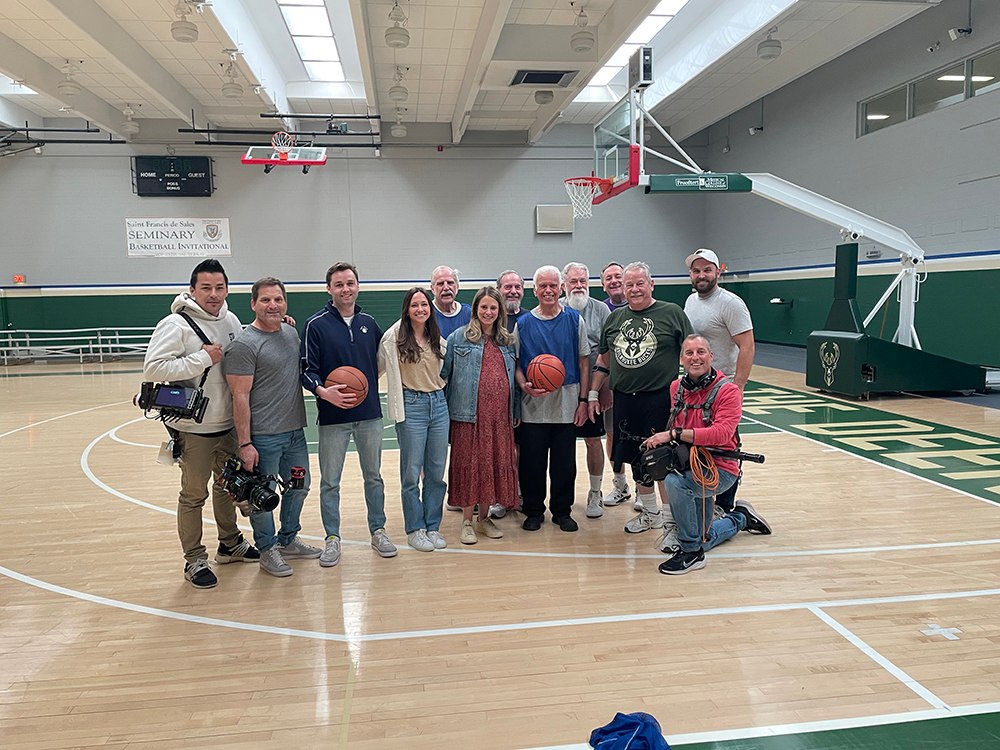 A group of filmmakers standing on a basketball court