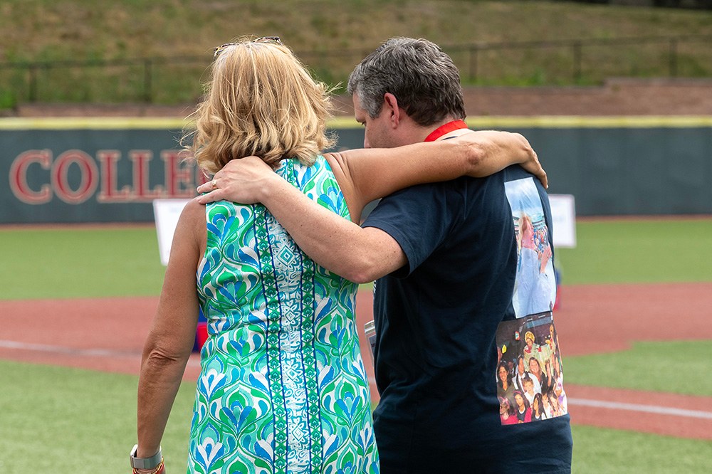 Two people walking with their arms around each other
