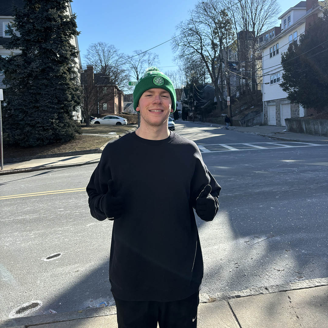 A man standing on a street with his thumbs up