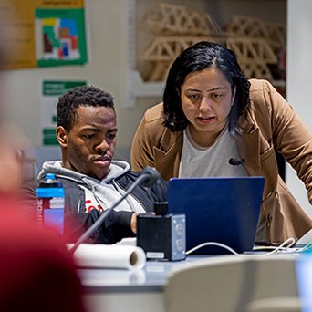 Student and professor looking at computer