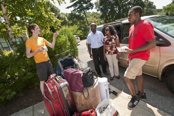 Students Moving In on Newton Campus. Sean Doyle (yellow) helps direct the Tala family moving in on Newton Campus. Protais Tala and his wife Joana assisting their son Anthony Tala '16 (red) in the move.